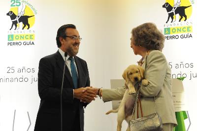 SM la Reina Doña Sofía, con un cahorro de futuro perro guía en sus brazos, saluda a Miguel Carballeda, presidente de la ONCE y su Fundación.jpg