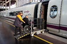 Usuario en silla de ruedas atendido por asistente servicio Atendo en el acceso al tren