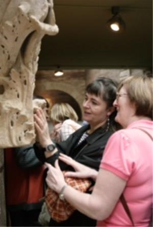 Voluntario acompaña persona ciega visita museo.jpg