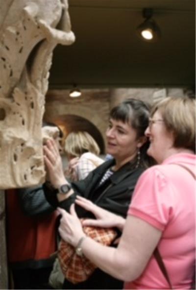 Voluntario acompaña persona ciega visita museo.jpg