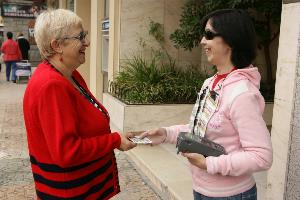 Vendedora cupón ciega atendiendo con su TPV a una clienta